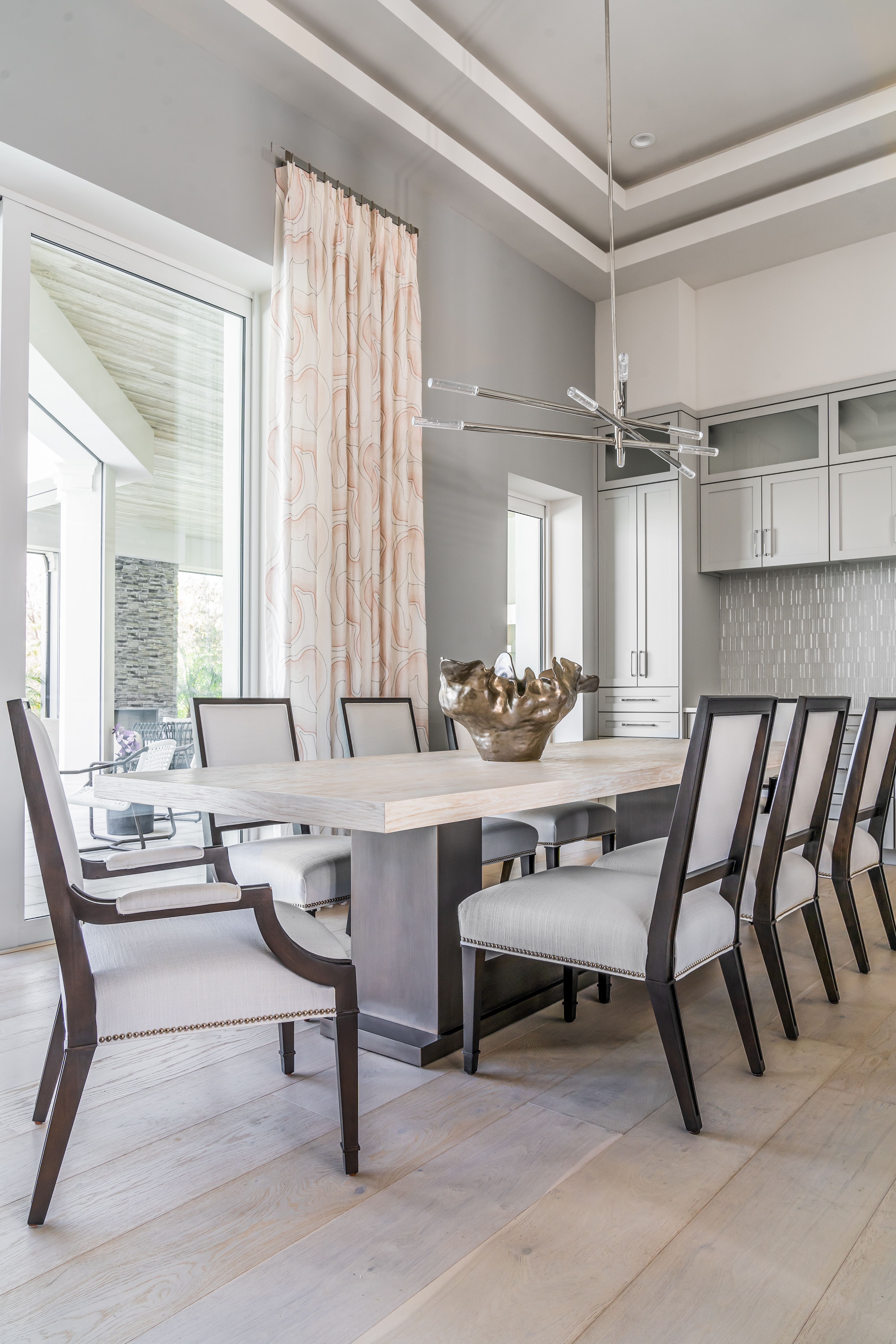 A coastal contemporary dining room design with a neutral palette, designed by Florida interior designer Brooke Meyer of Gulfshore Interior Design